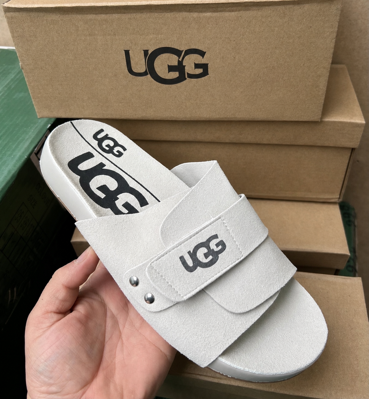 UGG тапочек крупным планом на фоне коробок
